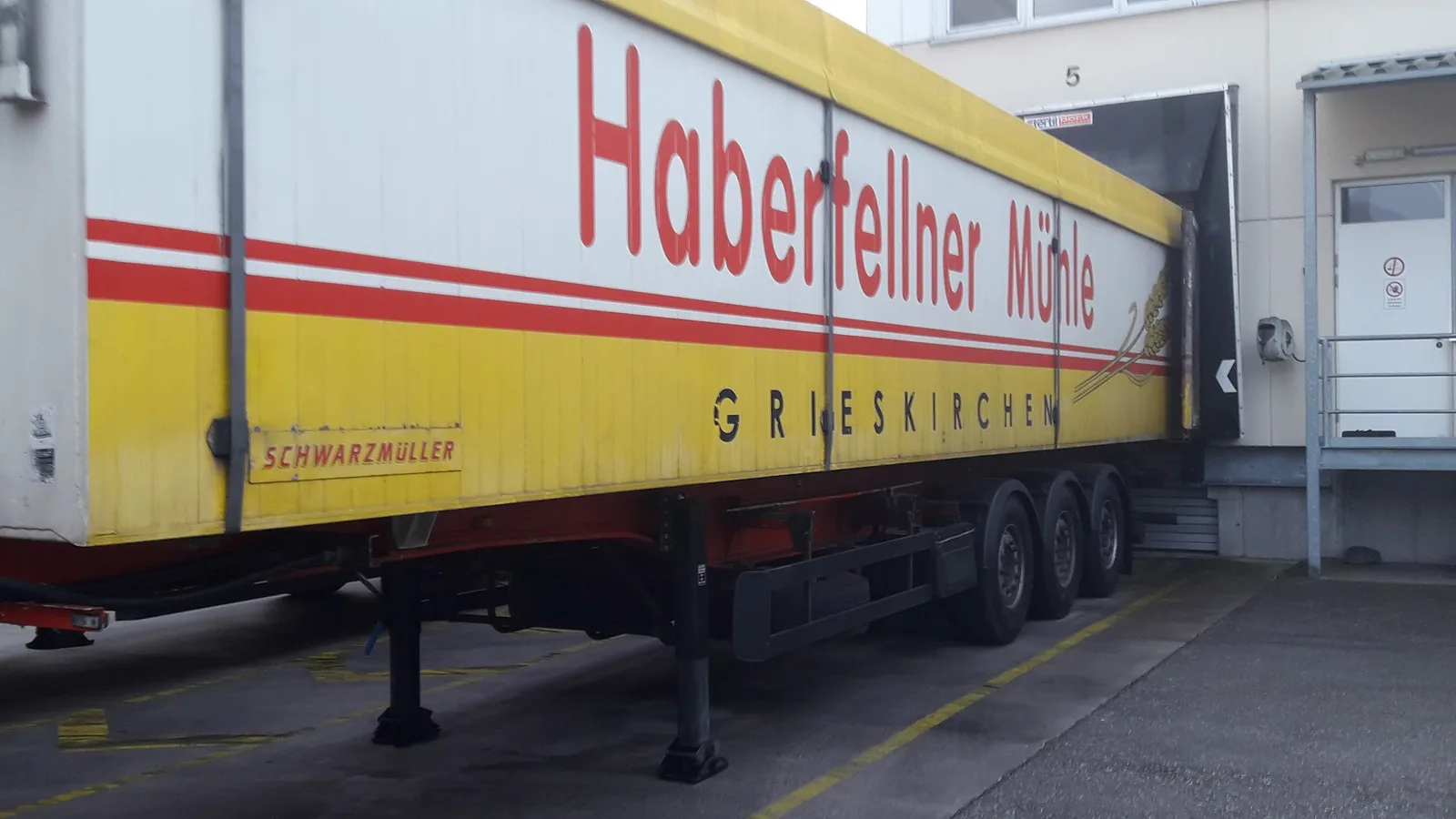 Gelber Auflieger mit der Aufschrift Haberfellner Mühle Grieskirchen an der Laderampe